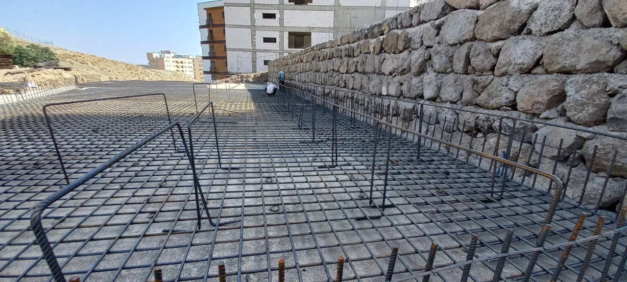 Foundation reinforcement beside a stone retaining wall at the Aras construction site